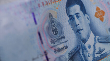 Counting Thai banknotes at a table during a financial transaction in Thailand