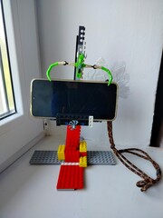 Homemade smartphone stand made of colorful Lego bricks. Creative DIY phone holder, toy construction, imaginative engineering design for mobile device support." © Валентина Башняк