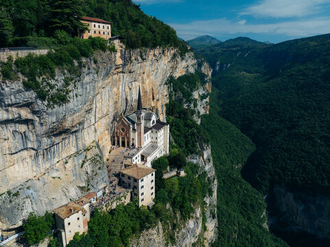 Aerial view of Santuario Madonna della Corona clinging to the cliffside, a beacon of faith against the rugged landscape, Madonna della Corona, Veneto, Italy.