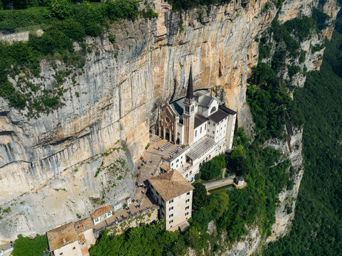 Aerial view of the Sanctuary of Madonna della Corona clinging dramatically to the sheer rock face, a beacon of faith amidst the rugged terrain, Madonna della Corona, Veneto, Italy.