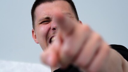 An angry smiling guy is bullying a weak person, pointing his finger at him and making fun of him.
Cruelty and mockery.
A guy is humiliating someone and laughing at another person or his friend - Powered by Adobe