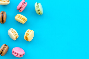 Brignt macarons for sweet break on blue background top view mock up