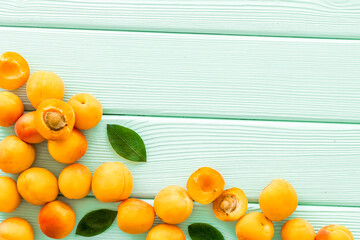 Fruit frame. Apricots and leaves on green wooden background top view space for text