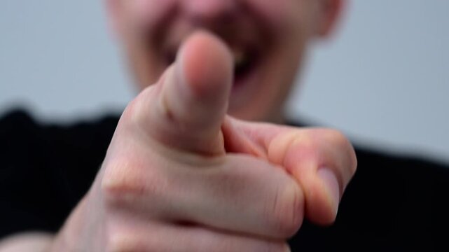 An angry smiling guy is bullying a weak person, pointing his finger at him and making fun of him.
Cruelty and mockery.
A guy is humiliating someone and laughing at another person or his friend