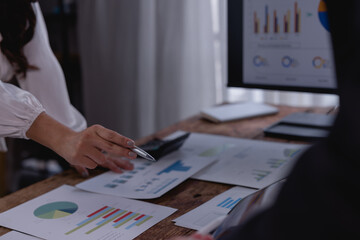 Business colleagues collaborating on a project, analyzing financial data through charts and graphs...