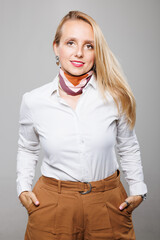 Businesswoman in neutral attire posing confidently in a professional setting during daytime, showcasing modern style and empowerment
