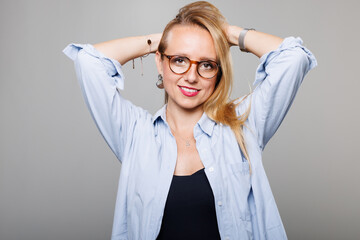 Businesswoman poses confidently with a stylish shirt, showcasing her professional demeanor in a minimalistic studio environment during daylight hours