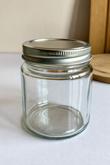 empty glass jar with metal lid on plain surface, product mockup