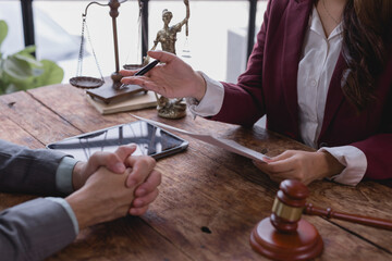 Female lawyer holding and presenting a contract to a client during a meeting in the office, engaging in legal discussions, offering advice, and navigating negotiations within the justice system