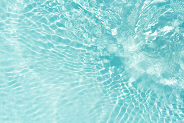 Obraz premium Blue water with ripples on the surface. Defocus blurred transparent blue colored clear calm water surface texture with splashes and bubbles. Water waves with shining pattern texture background.