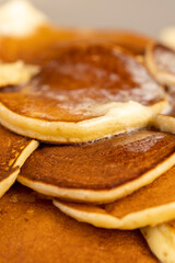 hot pancakes with butter that melts on the pancakes, a large pile of round pancakes with butter made from milk after cooking