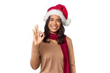 Filipino in Christmas attire and Santa hat cheerful and confident showing ok gesture.