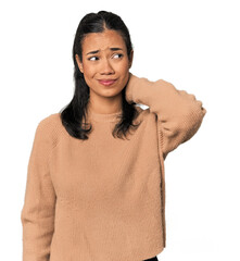 Young Filipina woman touching back of head, thinking and making a choice.
