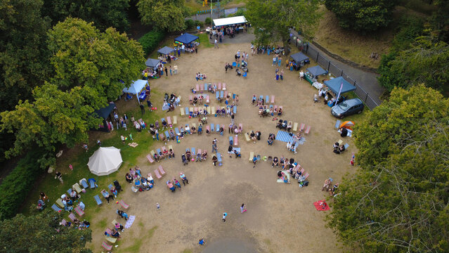 New Brighton, United Kingdom - 22 August 2025: Aerial view of Vale Park comes alive with vibrant gatherings, tents, chairs, and stalls nestled amidst lush green trees, creating a lively scene.