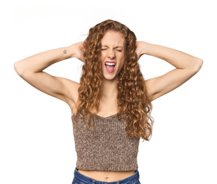 Simple redhead studio portrait covering ears with hands trying not to hear too loud sound.
