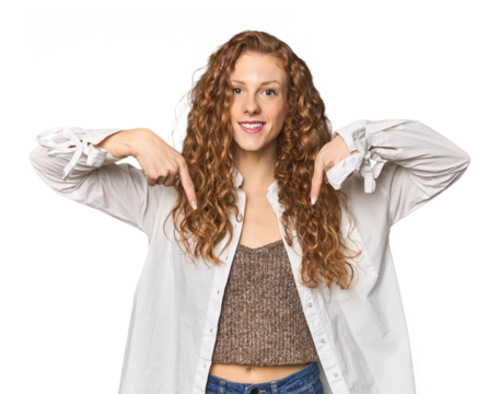 Simple redhead studio portrait points down with fingers, positive feeling.