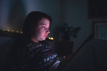 Girl using smart phone while lying on bed in bedroom