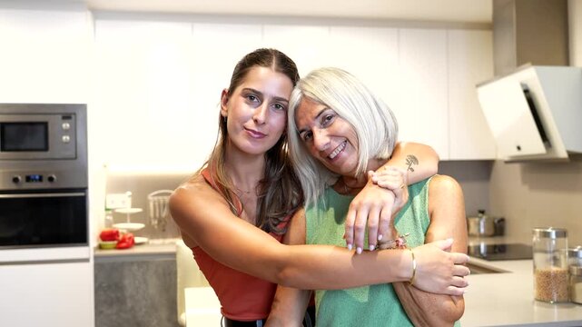 Heartwarming moment of mother and daughter embracing in kitchen