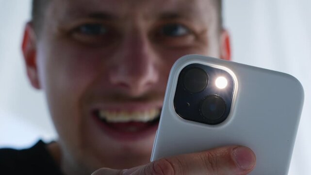 A man takes a photo of someone on a smartphone.
A man with a phone in his hands smiles and enjoys the content he has created.
Creating beautiful rare content.
A modern camera lens