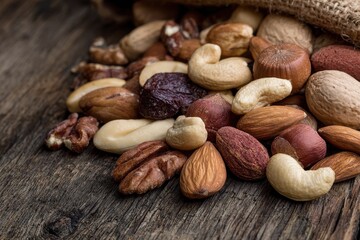 Bulk Nuts. Mixed Varieties of Nuts on Wooden Background
