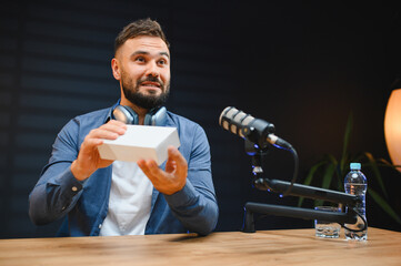 Video blogger recording podcast and showing product in studio