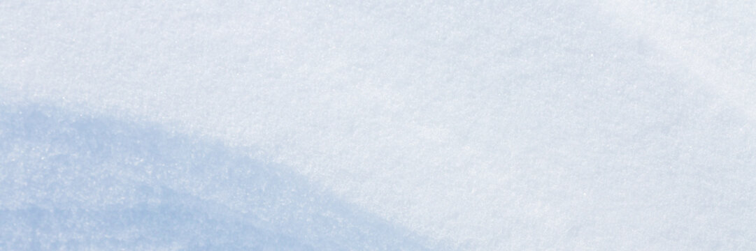 Beautiful winter background with snowy ground. Natural snow texture. Wind sculpted patterns on snow surface. Wide panoramic texture for background and design. Closeup top view with copy space. - Powered by Adobe