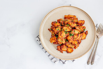 Freshly cooked air fryer chicken stir fry served in a ceramic plate garnished with cilantro