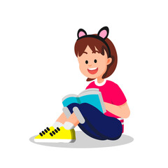 A little girl reads a book while wearing cat ear accessories