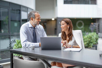 Business professionals engage in discussion and planning during a meeting at a modern office setting in the afternoon