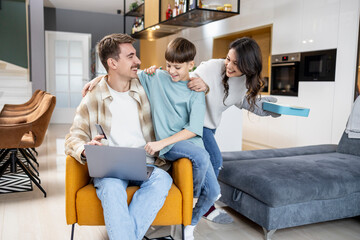 Family enjoying time together at home while working and playing in a modern living space