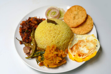 White Background Plate of Yellow Traditional Rice and Curry with Omelet.