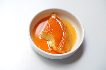 Eaten Sweet Caramel Pudding Piece in White Ceramic Bowl.
