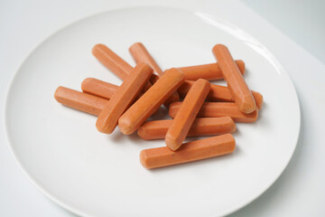 Uncooked Sausages on White Plate Closeup.