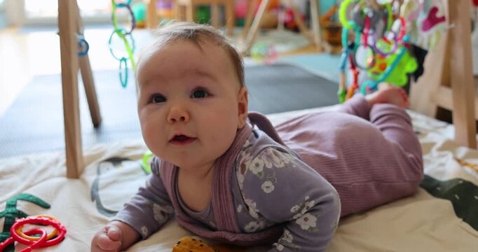 Baby &uuml;bt Bauchlage auf der Krabbeldecke