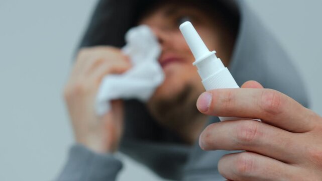 A young guy wipes his nose from snot during illness or allergies.
Use of nasal drops during a runny nose or sinusitis.
Respiratory diseases.
Runny nose and temperature