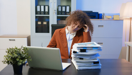 Tired young woman working late at the office, looking sleepy, using smartphone, wanting to relax,...