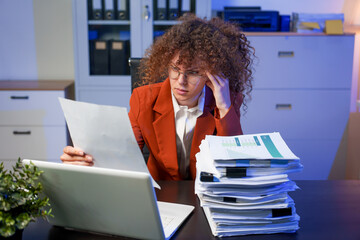 Tired young woman working late at the office, looking sleepy, using smartphone, wanting to relax,...