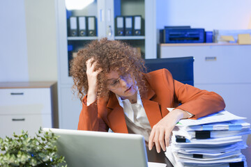 Tired young woman working late at the office, looking sleepy, using smartphone, wanting to relax,...