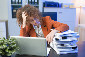 Tired young woman working late at the office, looking sleepy, using smartphone, wanting to relax,...
