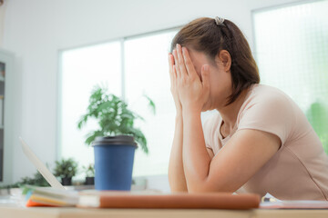 Tired young woman working late at the office, looking sleepy, using smartphone, wanting to relax,...