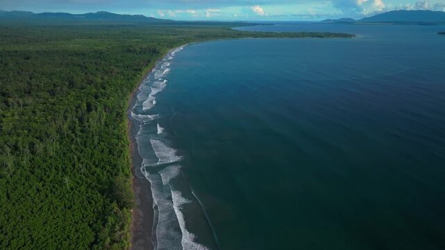 Cape Wom Public Beach Dogreto bay remote untouched coastline Wewak tropical jungle rainforest aerial drone Papua New Guinea PNG Yuo Mushu Island deep blue Bismarck Sea Pacific Ocean forward pan up
