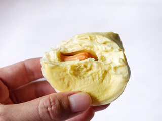 A delicious yellow durian fruit that was bitten in the hand.