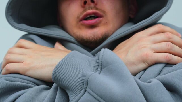 Severe cold and shivering man in hood can't warm up.
Shivering from cold and hypothermia in winter.
Energy crisis and heat cuts due to debts
