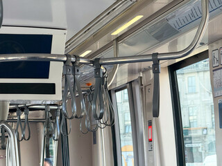 Hanging straps for passengers in tram interior. Public transport, safety, and urban mobility...