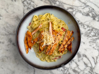 Tagliatelle pasta with grilled chicken and parmesan in creamy sauce. Cuisine, flavor, and gourmet dining in restaurant lifestyle and food culture.