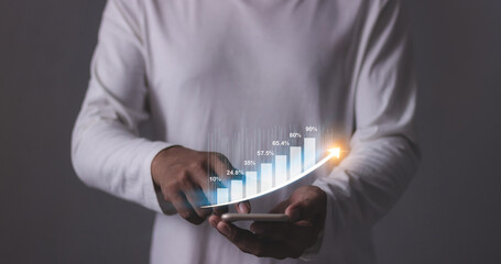 Young man with smartphone hand touching to visualize money growth The phone screen displays graphs...