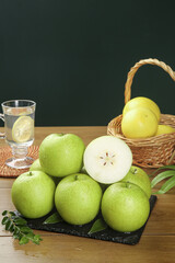 Fresh Green Apples on Slate Board with Lemon Water and Wicker Basket Display