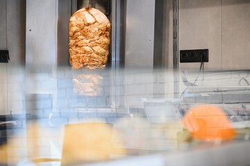 Shawarma rotating on a spit in a street food restaurant
