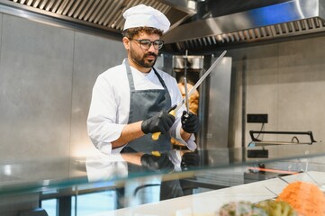 Chef sharpening knives getting ready to prepare shawarma or kebab in restaurant kitchen