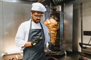 Chef preparing shawarma or kebab in a restaurant kitchen